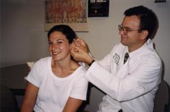 a doctor examining the ear of a female patient
