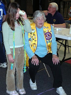 a young girl standing beside a sitting granny