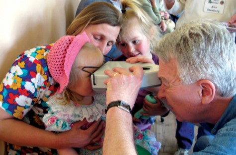 man giving young girl an eye exam